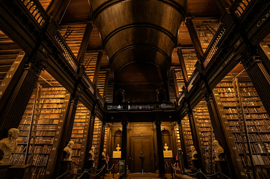 Historic library with tall wooden bookshelves and warm light